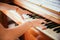 Girl is playing piano at home, high angle view, blurry background