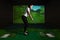 A girl playing screen golf. Golf Simulator.