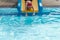 a girl playing slider in swimmimg pool