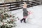 Girl playing with a snowman with pink knitted scarf