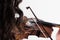 Girl playing the violin. Close-up. View from the shoulder side through the hair. The bow touches the strings. Musical theme. White