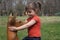 Girl playing with wooden deer statue