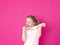 Girl is playing with yellow slime in front of pink background