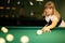 Girl plays billiards