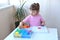 The girl plays the Children`s educational constructor puzzle with a screwdriver, a screwdriver and shurukas with multi-colored