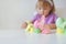 The girl plays with multi-colored eggs with rabbits of origami