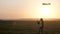 Girl plays with a multi-colored kite on field in rays of sun. Teenager dreams of flying and becoming pilot. colored kite