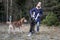 Girl plays with two husky dogs in winter European Park. Dog jumps on the owner, puts his paws on his chest