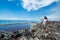 Girl pointing far away standing at the top of trash mountain at garbage dump