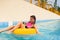 Girl in a pool sitting in a rubber inflatable float.
