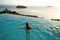 Girl in the pool at sunset with views of the mountains and the sea