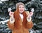 Girl portrait at winter forest, snowy weather, showing big snowflake toy.