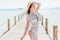 Girl pose at sea pier in straw hat and sunglasses. Woman in swimsuit on tropical beach on sunny blue sky. Summer vacation. Re