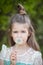 Girl poses with an air dandelion on the background of her face