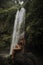 A girl poses in a bikini in a waterfall in a forest