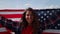 Girl posing at camera with american flag. Traveler waving national american flag