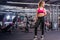 Girl posing in the gym with dumbbell in hand