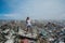 Girl posing among mountains of trash at garbage dump