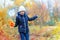 A girl posing near river and enjoys autumn, beautiful nature with yellow leaves