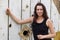 Girl posing near a wooden reel for cable. Put your hands on the reel