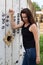 Girl posing near a wooden reel for cable. Put your hands on the reel