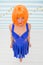Girl posing striped background of studio. Lady red or ginger wig posing in blue dress. Comic actress concept. Woman
