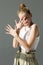 Girl posing in the studio. Palms in front of the face.