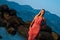 Girl posing at sunset on a background of stones, mountains and the sea