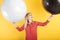 Girl posing with two giant balloons on a yellow background