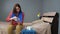 Girl pours saline solution for inhalation into nebulizer. Young woman dressed in red shirt and blue towel sits alone in