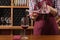 Girl pours wine into a glass of a beautiful decanter, concept