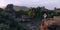 Girl practicing king dancer yoga pose on the edge of a high cliff in front of beautiful forest and mountain scenery in purple