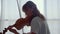 Girl practicing music on violin with bow. Violinist playing chords on violin