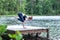 Girl practicing yoga, doing Bakasana exercise, Crane pose,  on the lake.   Concept of healthy life and natural balance