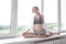 Girl practicing yoga, doing splits, stretching exercise on windowsill at home