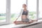 Girl practicing yoga, doing splits, stretching exercise on windowsill at home