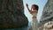 Girl practicing yoga exercises standing rocky Ursa coast. Woman crossing hands.