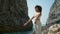 Girl practicing yoga exercises standing rocky Ursa coast. Woman crossing hands.