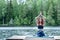 Girl practicing yoga in the nature on the lake. Female happiness. Landscape background, space for text