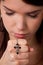 Girl praying hands with cross