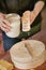 The girl prepares ceramic dishes for milk burn. Pours milk on a clay object.