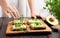 Girl preparing sandwiches with avocado spread and microgreen