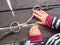 Girl preparing steel horse snaffle-bit on wooden table