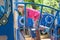 A girl preschooler with a braid climbs a blue iron staircase in the playground