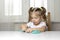 Girl preschooler sits at a table and sculpts from turquoise dough for modeling