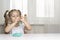 girl preschooler sits at a table and sculpts from turquoise dough for modeling. activities with children at home on self-isolation