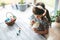 Girl preschooler sitting at the table painting gypsum Easter egg