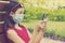 Girl in protective mask holding a smartphone. teen girl siting on bench in green park with mobile phone. First stage of loosening