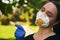 Girl in a protective mask smiles with dandelion in hand, COVID-19 coronavirus prevention, nature protection, quarantine time