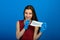 Girl in protective medical mask and blue gloves on blue background. close-up portrait of a woman in a transparent mask